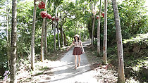 Walking down outdoor trail wearing sun hat in short dress